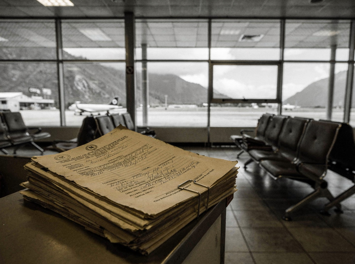 An empty airport gate area at Tenzing-Hillary Airport in Lukla, Nepal, under an overcast sky.