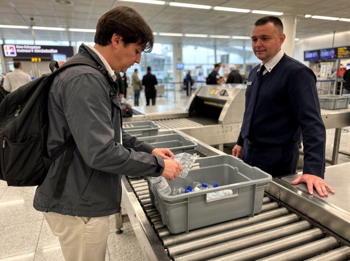 A security checkpoint at a busy international airport, during the day.
