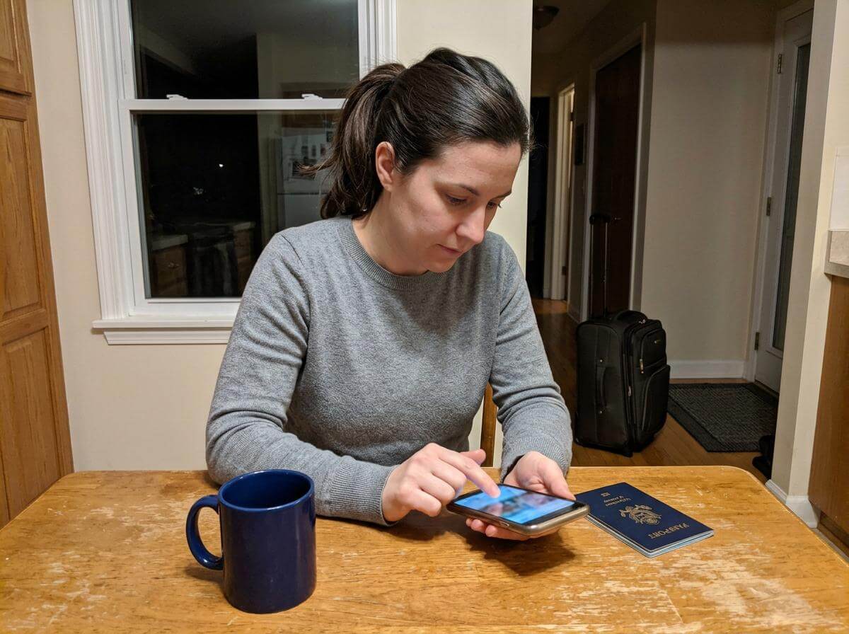 Traveler installing a Turkey eSIM on her phone at home before flying (ATC Intel)